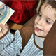 A little saint holds a picture of Our Lady of Guadalupe