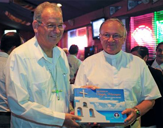 Mons. Pedro Pablo Elizondo, obispo de la Prelatura, regala a Mons. Zygmunt Zimowski, presidente del Pontificio Consejo para los Agentes Sanitarios, el libro conmemorativo.