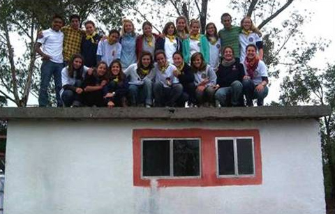 Grupo de misioneras sobre una de las casas que construyeron durante la misión en el Estado de México.