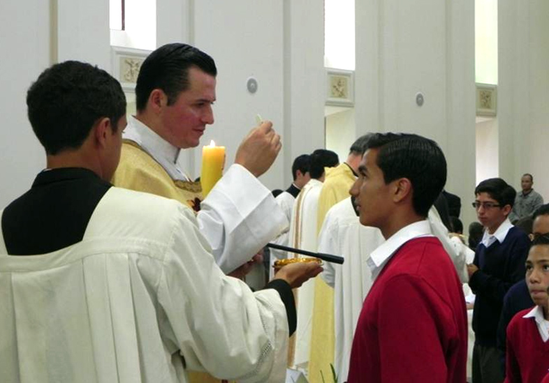 El P. Roberto Carlos Lazalde, L.C., ya diácono, imparte la comunión a los alumnos del centro vocacional.