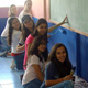 Grupo de chicas pitando una escuela de escasos recursos.