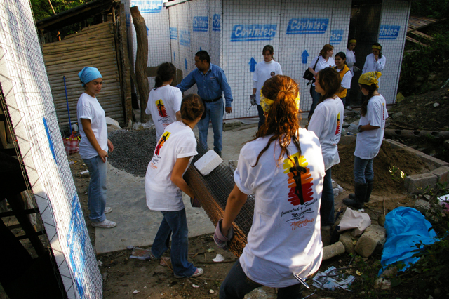 Jóvenes construyendo casas.