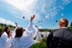 Everest graduates toss their caps after saying a final decade of the Rosary around their school's Marian shrine