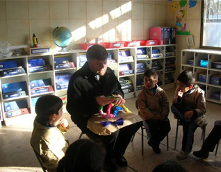 El P. Jaime Ortiz de Lazcano, de la parroquia Emanuel, recibe un regalo de los niños del Colegio Mano Amiga de Recoleta, el primero de los tres colegios para niños de escasos recursos en Chile.