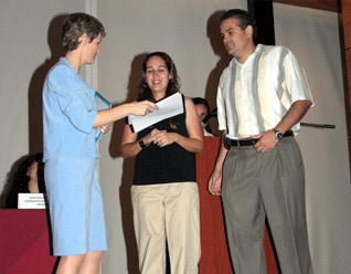 Nilda Treviño de Flores y Sergio Flores, reciben un reconocimiento de manos de Miss Cathie Zentner.